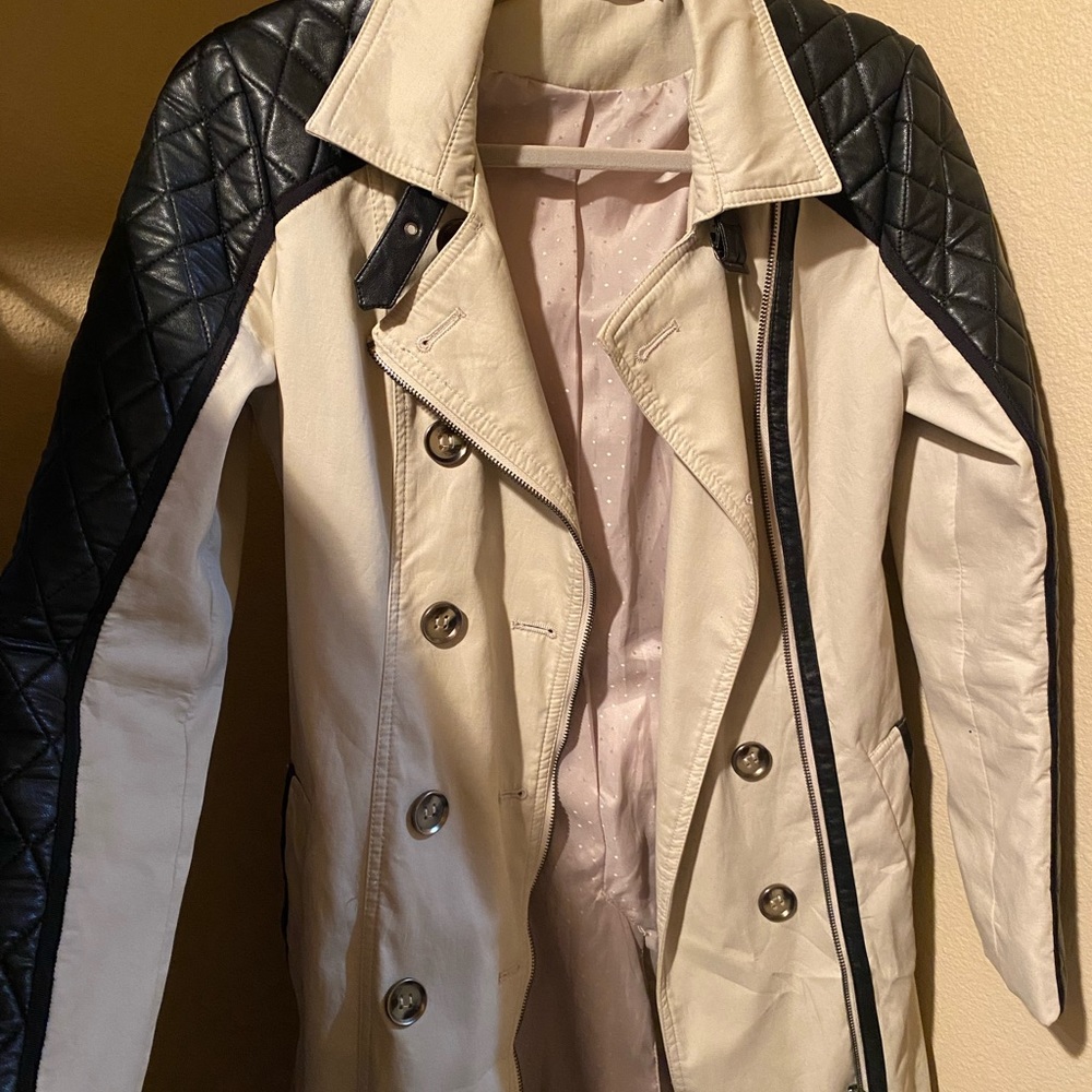 Tan trench coat with black leather detailing on arms